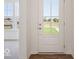 Bright foyer with white door and window, contrasting dark wood-look floors, and view to the front yard at 13752 N George Ct, Camby, IN 46113