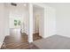 Bright interior showcasing dark wood-look flooring, neutral carpeting, and a view of the front yard at 13752 N George Ct, Camby, IN 46113