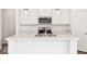 Close-up of the kitchen island with stainless steel appliances and white marble countertops at 13752 N George Ct, Camby, IN 46113