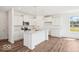 Modern kitchen featuring white cabinetry, an island, stainless steel appliances, and wood floors at 13752 N George Ct, Camby, IN 46113