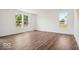 Light-filled living room featuring wood floors, white walls, and bright windows with outdoor views at 13752 N George Ct, Camby, IN 46113