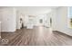 Open-concept living area with wood floors, white walls, and seamlessly connected to the modern kitchen at 13752 N George Ct, Camby, IN 46113