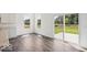Open living room with wood floors, white walls, large windows, and sliding door to the backyard at 13752 N George Ct, Camby, IN 46113