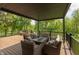 Cozy outdoor living space on the covered deck, overlooking the lush greenery and tranquil pond views at 1527 Canyon Oak Ln, Columbus, IN 47201