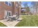 Backyard featuring a covered porch, a dining table set, green grass, and an outdoor stairwell at 1527 Canyon Oak Ln, Columbus, IN 47201
