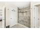 Bathroom featuring walk-in shower with glass door, gray tile, and adjoining bedroom at 1527 Canyon Oak Ln, Columbus, IN 47201