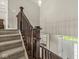 View from top of stairs to main foyer with stairs covered with neutral colored carpet and white front door at 1527 Canyon Oak Ln, Columbus, IN 47201