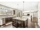 Open-concept kitchen showcasing dark cabinets, granite island, stainless steel appliances, and view to living space at 1527 Canyon Oak Ln, Columbus, IN 47201