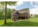 The house features a spacious back deck with stairs, surrounded by lush greenery at 1527 Canyon Oak Ln, Columbus, IN 47201