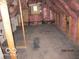 Spacious attic featuring exposed beams, pink insulation, and hardwood flooring at 1546 S New Jersey St, Indianapolis, IN 46225