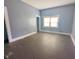 A vacant bedroom has painted blue walls, hardwood floors, a white baseboard, and a window with blinds at 1546 S New Jersey St, Indianapolis, IN 46225