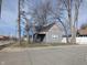 Charming single-story home with gray siding, a black roof, and mature trees in a residential neighborhood at 1546 S New Jersey St, Indianapolis, IN 46225
