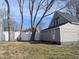 Gray single-story house with dark roof and white vinyl fence, surrounded by mature trees, creating a private backyard at 1546 S New Jersey St, Indianapolis, IN 46225