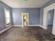 Bare living room with light-blue walls, worn hardwood floors, and doorways that lead to other rooms in the house at 1546 S New Jersey St, Indianapolis, IN 46225
