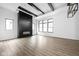 Open-concept living room featuring hardwood floors, a modern fireplace, and ample natural light from large windows at 17354 Newton Main St, Westfield, IN 46074