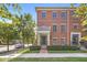 Brick townhouse with covered entry, set against a backdrop of lush greenery and blue skies at 2183 Glebe St, Carmel, IN 46032