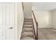 Carpeted staircase featuring a wooden handrail and white trim, leading to the upper level of the home at 2183 Glebe St, Carmel, IN 46032