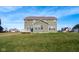 Large backyard showcasing lawn, the home's rear, and a deck. Houses in the distance create a neighborhood backdrop at 2314 Angelina Way, Greenwood, IN 46143