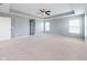 Large bedroom with neutral carpet, tray ceiling with ceiling fan, and natural light from multiple windows at 2314 Angelina Way, Greenwood, IN 46143