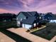 Twilight aerial view of home with illuminated windows and a two-car garage, set against a colorful sky at 2314 Angelina Way, Greenwood, IN 46143
