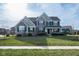 Inviting two-story home with a manicured lawn and a combination of brick and green siding at 2314 Angelina Way, Greenwood, IN 46143
