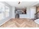 Open living room with large windows and light wood herringbone floors, perfect for entertaining at 2314 Angelina Way, Greenwood, IN 46143