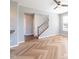 Spacious living room with light wood herringbone floors and a staircase in the background at 2314 Angelina Way, Greenwood, IN 46143