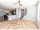 Bright living room with open concept to the kitchen, featuring herringbone floors and a staircase at 2314 Angelina Way, Greenwood, IN 46143