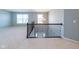 Spacious loft features neutral carpet, iron railing, modern chandelier, and natural light from large windows at 2314 Angelina Way, Greenwood, IN 46143