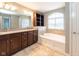 Bathroom with double vanity, soaking tub with tiled surround, and plenty of natural light at 2314 Angelina Way, Greenwood, IN 46143