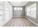Bright office space with built-in shelving, wood-look tile flooring, and natural light from three windows at 2314 Angelina Way, Greenwood, IN 46143