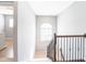Well-lit staircase with dark wood railing and wrought iron spindles, featuring an arched window at 2314 Angelina Way, Greenwood, IN 46143