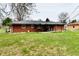 Brick home exterior with a covered patio, ideal for relaxing and entertaining in the backyard at 2315 Cardinal Dr, Indianapolis, IN 46227