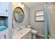 Bathroom featuring a round mirror, white vanity and toilet, plus shower and tub at 2315 Cardinal Dr, Indianapolis, IN 46227