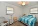 Bright bedroom showcasing a cozy bed with blue striped bedding, and natural light from two windows at 2315 Cardinal Dr, Indianapolis, IN 46227