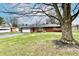 Well-maintained brick home with an attached garage and mature tree in the front yard at 2315 Cardinal Dr, Indianapolis, IN 46227