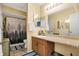 Neutral bathroom featuring a single sink vanity, shower with curtain, and a decorative mirror at 3051 Arrow Wood Ln, Indianapolis, IN 46214