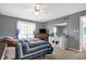Spacious bedroom with a large window, TV, ceiling fan, and a comfortable sleeping area at 3051 Arrow Wood Ln, Indianapolis, IN 46214
