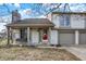 Charming two-story home with a red front door and a two-car garage nestled in a quiet neighborhood at 3051 Arrow Wood Ln, Indianapolis, IN 46214