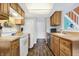 Well-maintained kitchen featuring wood cabinets, white appliances, and wood-look flooring at 3051 Arrow Wood Ln, Indianapolis, IN 46214