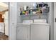 Functional laundry area equipped with a washer, dryer, and shelving for storage at 3051 Arrow Wood Ln, Indianapolis, IN 46214