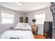 Well-lit bedroom features a bed with white linens, hardwood floors, neutral walls, and decorative accents and decor at 311 S Webster Ave, Indianapolis, IN 46219