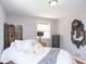 Well-lit bedroom features a bed with white linens, hardwood floors, neutral walls, and decorative accents and decor at 311 S Webster Ave, Indianapolis, IN 46219