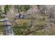 Aerial view of a house and shed surrounded by lush greenery and mature trees at 3357 Saddle Club Rd, Greenwood, IN 46143