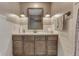 Well-lit bathroom featuring a wooden vanity with a sink, neutral countertop, and decorative sconce lighting at 3357 Saddle Club Rd, Greenwood, IN 46143