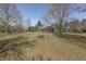 A gray two-story home nestles among bare trees in a winter landscape, set on a grassy lawn under a bright sky at 3357 Saddle Club Rd, Greenwood, IN 46143