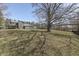 View of a charming gray home featuring a spacious lawn and mature trees casting shadows, set under a clear blue sky at 3357 Saddle Club Rd, Greenwood, IN 46143