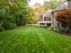 Spacious backyard with lush green grass, mature trees, swing and home's rear exterior at 3727 Tributary Ct, Westfield, IN 46062