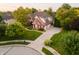 Aerial view of a brick two-story home with mature trees, manicured lawn and long driveway at 3727 Tributary Ct, Westfield, IN 46062