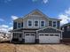 Two-story home featuring a two-car garage, blue siding, and a well-lit exterior at 3845 Andean Dr, Bargersville, IN 46106